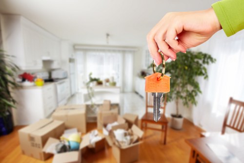 Removal team loading furniture in Scotland with recycling containers nearby