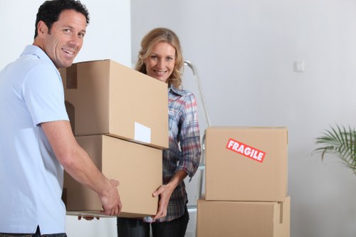Movers carrying furniture down a stairwell in a Glasgow flat