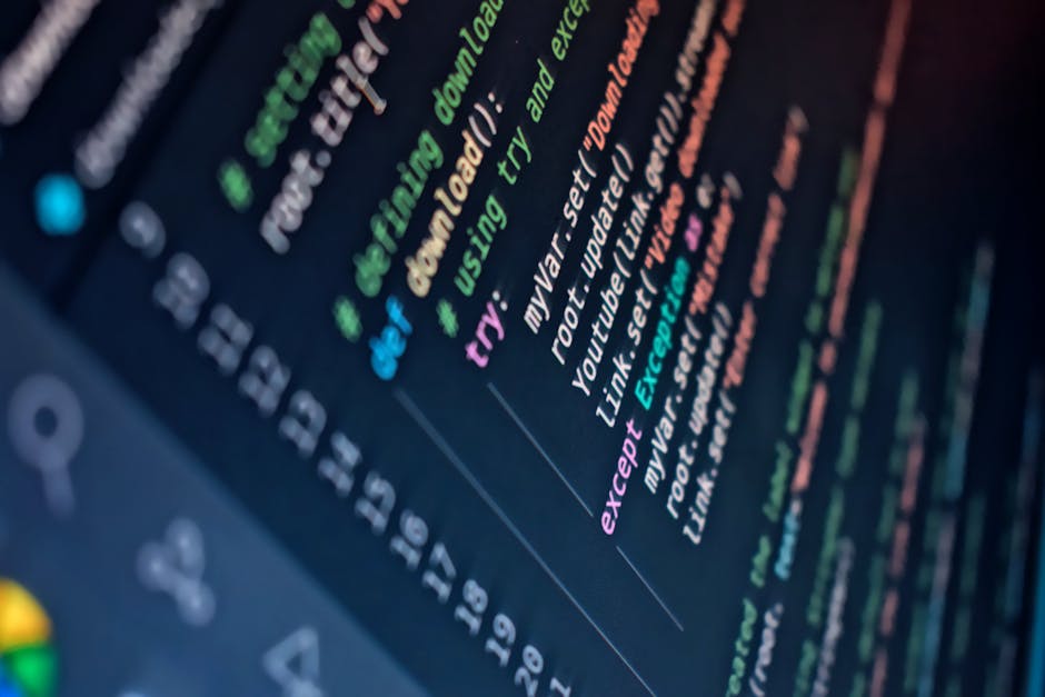 Close-up of a person's hands operating a laptop computer on a dark surface, with the screen displaying lines of code and text editor windows. The background is blurred, emphasizing the focus on the ha